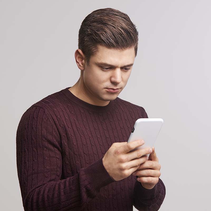 Portrait of a young white man using a smartphone